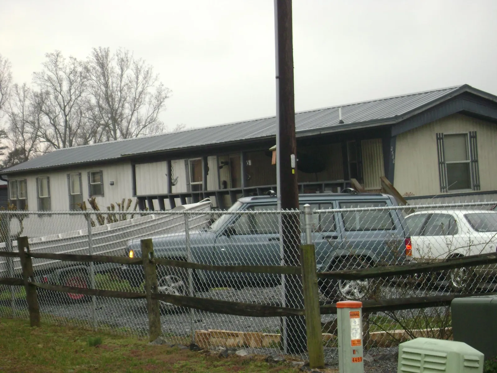 Dark metal roof on a long single story building behind a chain link fence in Philipsburg
